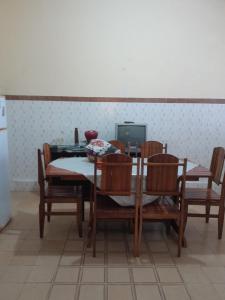 une salle à manger avec une table, des chaises et une télévision dans l'établissement Casa Histórica no coração de Cachoeira, à Cachoeira