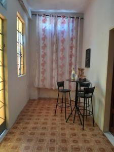 une pièce avec une table, des chaises et une fenêtre dans l'établissement Casa Histórica no coração de Cachoeira, à Cachoeira