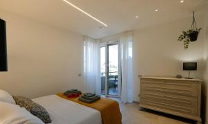 a bedroom with a bed and a dresser and a window at Blue Eagle - Villafranca Verona in Villafranca di Verona