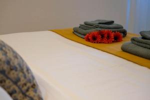 a row of towels on a wooden tray on a bed at Blue Eagle - Villafranca Verona in Villafranca di Verona +2 photos