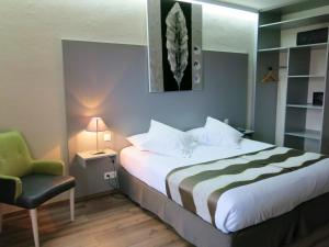 um quarto de hotel com uma cama com uma cadeira e um candeeiro em Hôtel Le Bristol Strasbourg Gare em Estrasburgo