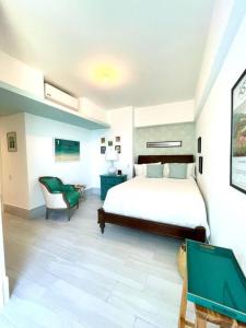 a bedroom with a large bed and a chair at Beachfront FL21 Con Tina Aquarella in La Puntica de Juan Dolio