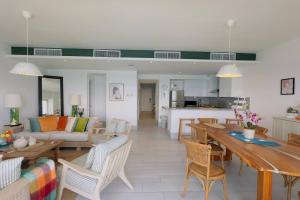 a living room with a table and chairs and a kitchen at Beachfront FL21 Con Tina Aquarella in La Puntica de Juan Dolio