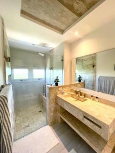 a bathroom with a large sink and a large mirror at Beachfront FL21 Con Tina Aquarella in La Puntica de Juan Dolio
