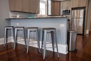 eine Küche mit drei Barhockern an einer Theke in der Unterkunft St Philip Gem 5 Bed-5 Bath Steps to FQ - Monthly in New Orleans