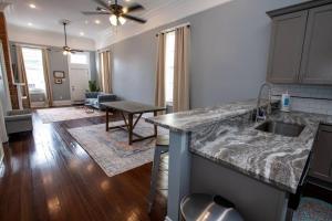 eine Küche mit Spüle und ein Wohnzimmer in der Unterkunft St Philip Gem 5 Bed-5 Bath Steps to FQ - Monthly in New Orleans