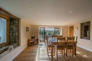 eine Küche und ein Esszimmer mit Tisch und Stühlen in der Unterkunft The Barn on Loch Tay - Hot Tub in Lawers