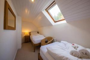 Zimmer im Dachgeschoss mit 2 Betten und einem Fenster in der Unterkunft The Barn on Loch Tay - Hot Tub in Lawers