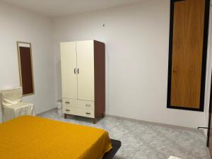a bedroom with a yellow bed and a cabinet at Magenta49 in Bernalda