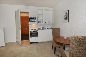 a kitchen with a table and a stove top oven at Studio apartment in Kaivoksela for two persons in Vantaa