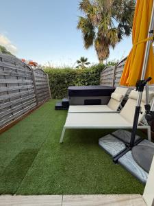 a patio with two chairs and an umbrella and grass at Ti Kaz Paradise in Le Diamant +16 photos