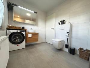 a bathroom with a washing machine and a toilet at Ferienwohnung Paradies in Osnabrück +32 photos