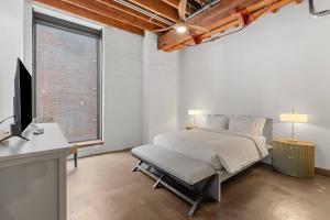 a bedroom with a bed and a desk and a television at Brick & Bed, Riverfront Lofts, P 4J in Saint Louis