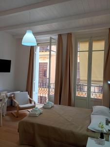 a bedroom with a large bed and a balcony at WHITE MOON CAGLIARI via Dettori 5 Centro in Cagliari