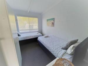 エスペランスにあるEsperance Little Units 1のベッドが2つと窓がある小さな部屋