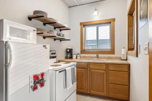 a kitchen with a white refrigerator and a sink at Peaceful Riverfront Cabin Sleeps 4 Decatur Nebraska in Onawa