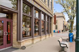a bench on a sidewalk in front of a store at The Roost 16 on Front 2BR Private Hot Tub Patio in Traverse City