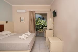 a hotel room with two beds and a balcony at Karras Livin in Laganas