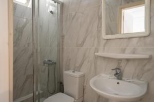 a bathroom with a shower and a toilet and a sink at Karras Livin in Laganas +27 photos