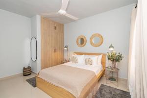 a bedroom with a large bed and two mirrors at Cozy 1-BR Apartment in Bayahibe in San Rafael del Yuma +23 photos
