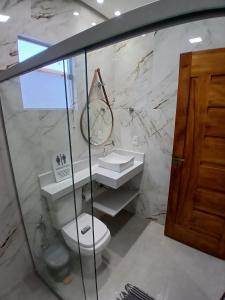 ein Badezimmer mit Toilette, Waschbecken und Spiegel in der Unterkunft Hospedaria Transcendental - Mucugê-BA in Mucugê