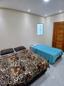 2 Betten in einem Zimmer mit Leopardenmuster in der Unterkunft Hospedaria Transcendental - Mucugê-BA in Mucugê