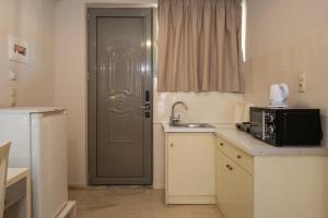 a kitchen with a door and a sink and a microwave at Karras Livin in Laganas