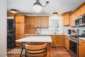 Whimsical Historic Getaway Near Golf Skiing and Wisconsin Southern Lakes في Genoa City: مطبخ بدولاب خشبي وقمة بيضاء