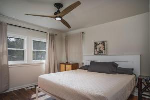 Whimsical Historic Getaway Near Golf Skiing and Wisconsin Southern Lakes في Genoa City: غرفة نوم بها سرير ومروحة سقف