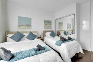 two beds in a bedroom with blue pillows on them at Lakeview Unit - sleeps 11 people near CN Tower Union Rogers Centre and Convention Centre in Toronto +33 photos