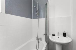 Un baño blanco con ducha y lavabo. en Stylish Stay in Inverkeithing., en Fife 17 fotos más