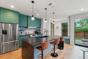 eine Küche mit grünen Schränken und eine große Insel mit Barhockern in der Unterkunft Modern Luxury in the Heart of Austin 3BR 3BA with Huge Balcony in Austin