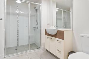 a bathroom with a shower and a sink and a toilet at Affordable CBD 2Beds and Ducted AC Walk to everything in Brisbane +8 photos