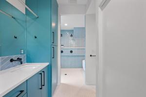 ein blaues Badezimmer mit Waschbecken und Dusche in der Unterkunft Modern Luxury in the Heart of Austin 3BR 3BA with Huge Balcony in Austin + 38 Fotos