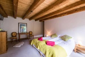 a bedroom with a bed and two chairs at La Ferme du Château in La Chapelle-dʼAbondance