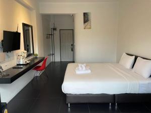 a hotel room with a large bed and a desk at Azz Hotel in Chiang Mai