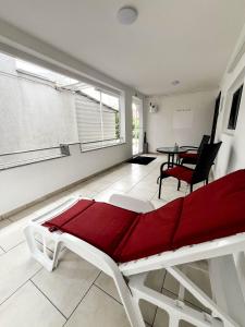 a living room with a red bed and a table at Apartmani MOSLAVINA i parking in Kutina