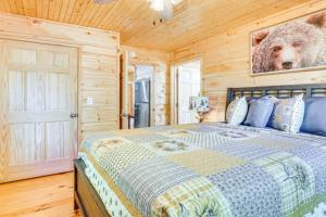 una camera da letto con un letto con una foto di un orso appesa al muro di River Escape River Front Cabin a Tellico Plains