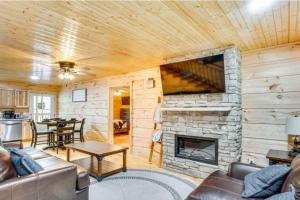 un soggiorno con camino in pietra in una baita di tronchi di River Escape River Front Cabin a Tellico Plains