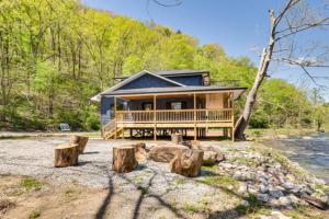 una grande casa in tronchi con un grande portico e alberi di River Escape River Front Cabin a Tellico Plains