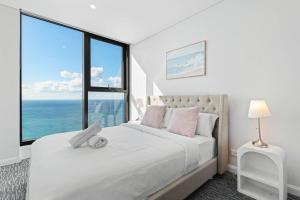 a bedroom with a bed with a large window at Oceanfront Luxury 2BR with Balcony and Views in Gold Coast +18 photos