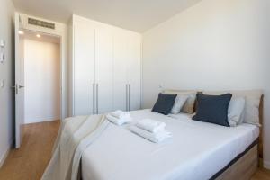 マドリードにあるWaou Plaza de España V - Alquiler Corta Duraciónの白いベッド(タオル付)が備わる客室です。