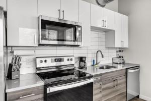 a kitchen with a stove and a microwave at Tropicana Field 1 Bed in Downtown With Free Parking in St Petersburg