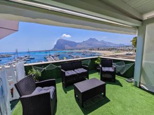 a balcony with chairs and a view of a harbor at Il Torrazzo da Francesca in San Vito lo Capo