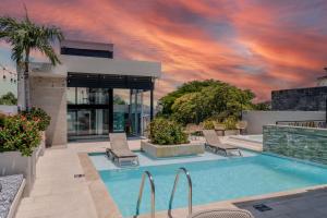 a swimming pool with a sunset in the background at Hotel Boutique Maree in Santa Marta