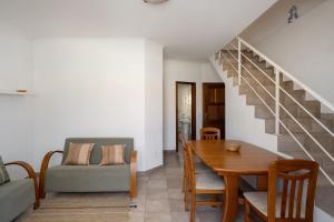 a living room with a dining room table and a staircase at Apartamento da Vila by An Island Apart in Porto Santo +16 photos