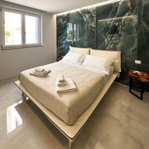 a bedroom with a large bed with towels on it at Paradiso esotico suite in Polignano a Mare