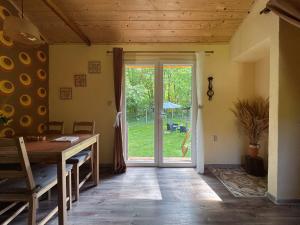 a room with a table and a sliding glass door at Unique Dutch Retro House "Stará Láska" - Natural Slovakia in Modrý Kameň