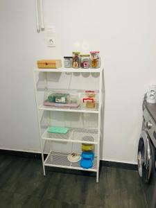 a white shelf in a kitchen next to a stove at Chambres Élysées in Athens