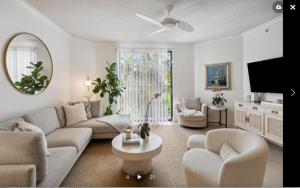 a living room with a couch and chairs and a tv at Downtown WPB Condo at the Square in West Palm Beach